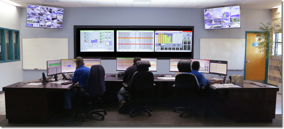 Foto de 3 personas sentadas frente a computadoras en un centro de control